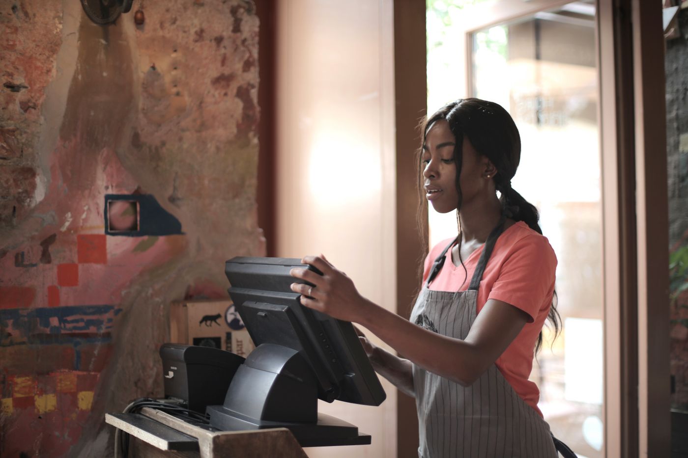 Retail cashier using a POS system at a checkout counter